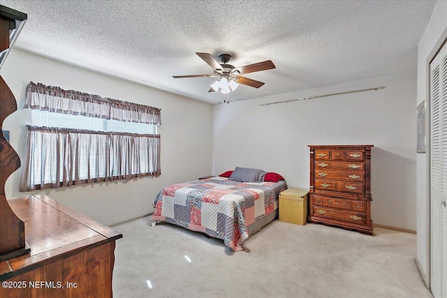 carpeted bedroom featuring a textured ceiling, ceiling fan, and a closet