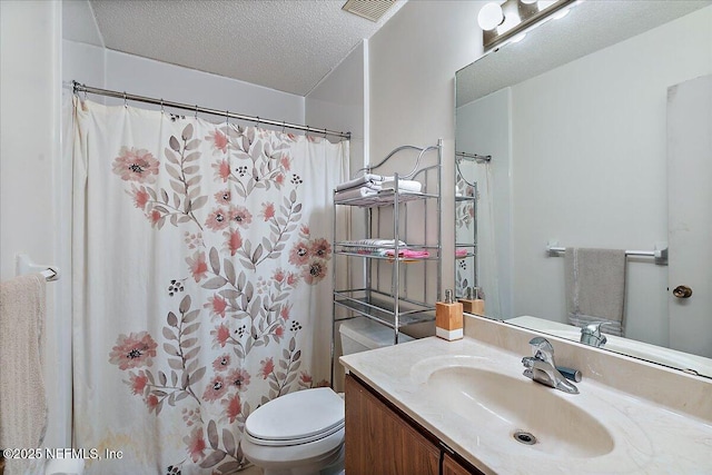 bathroom with vanity, curtained shower, toilet, and a textured ceiling