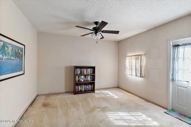 carpeted empty room with ceiling fan and a textured ceiling