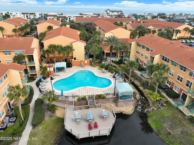 view of pool with a water view and a patio area