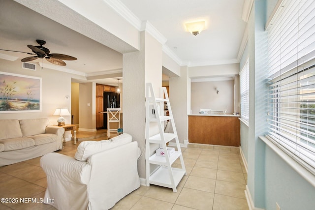 living room with crown molding, light tile patterned flooring, and ceiling fan