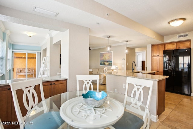 dining area with crown molding, sink, and light tile patterned floors