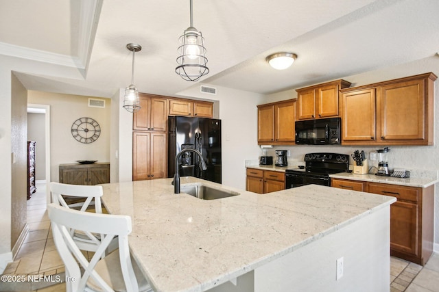 kitchen with sink, a center island with sink, a kitchen bar, and black appliances