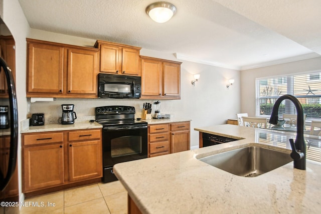 kitchen with light stone counters, light tile patterned floors, sink, and black appliances