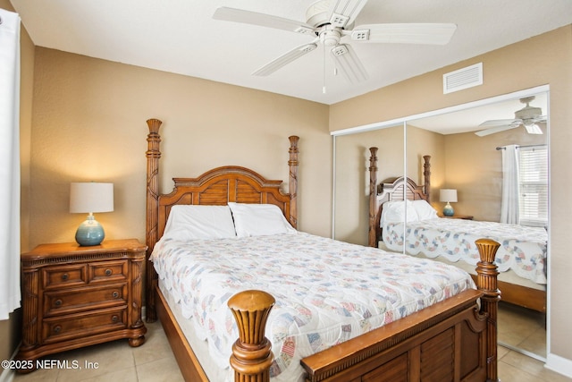 bedroom with light tile patterned floors, a closet, and ceiling fan