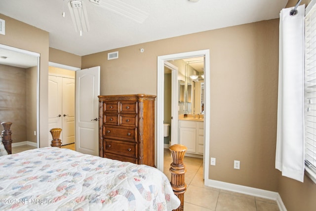 bedroom with light tile patterned flooring, ceiling fan, ensuite bathroom, and sink