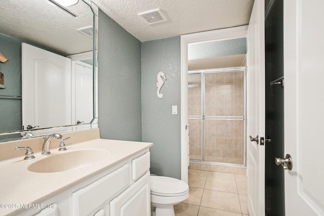 bathroom with a shower with door, vanity, and a textured ceiling