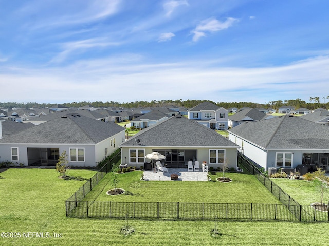 back of property featuring an outdoor fire pit, a lawn, a fenced backyard, and a residential view