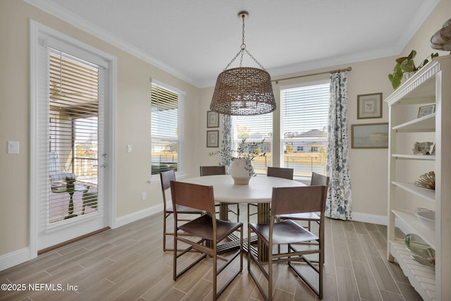 dining space with baseboards, ornamental molding, and wood finish floors