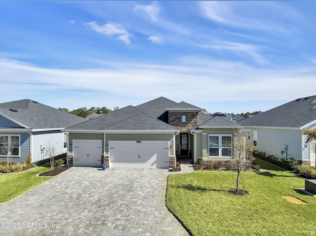 view of front of property with stone siding, a front lawn, decorative driveway, and an attached garage