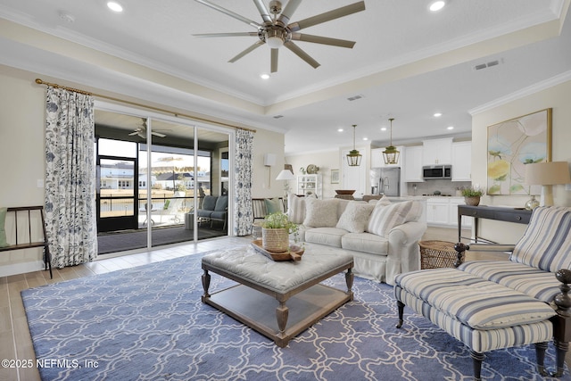 living room featuring a raised ceiling, ornamental molding, ceiling fan, and light hardwood / wood-style flooring