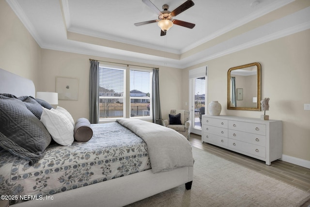 bedroom with a raised ceiling, ornamental molding, and light hardwood / wood-style flooring