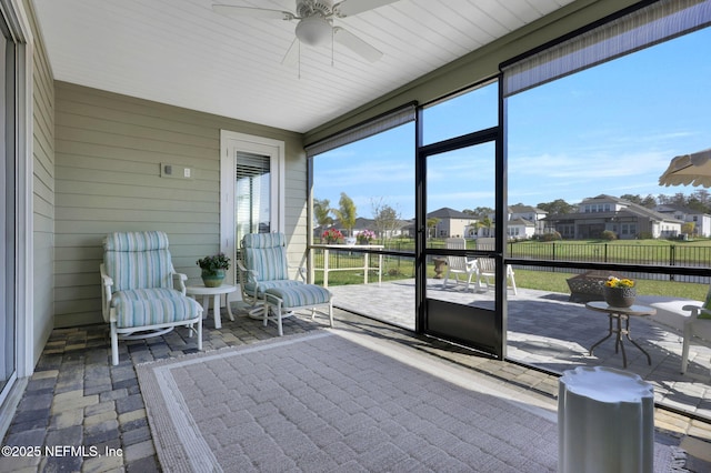 unfurnished sunroom featuring ceiling fan