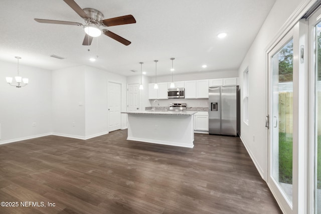 kitchen with pendant lighting, white cabinetry, stainless steel appliances, and a center island with sink