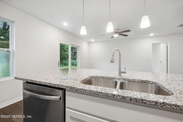 kitchen with dark hardwood / wood-style flooring, dishwasher, sink, and light stone countertops