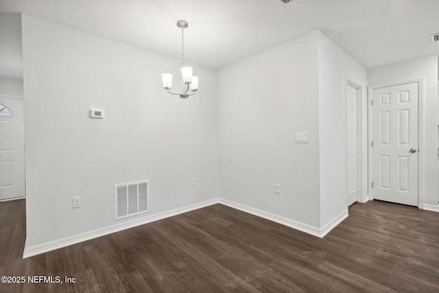 unfurnished dining area featuring dark wood-type flooring and a chandelier