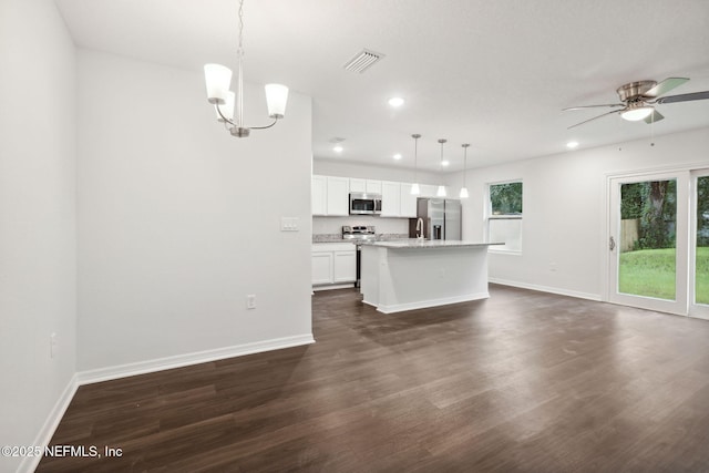 kitchen featuring pendant lighting, stainless steel appliances, dark hardwood / wood-style floors, a center island, and white cabinets