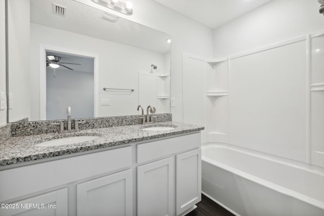 bathroom featuring ceiling fan, washtub / shower combination, and vanity