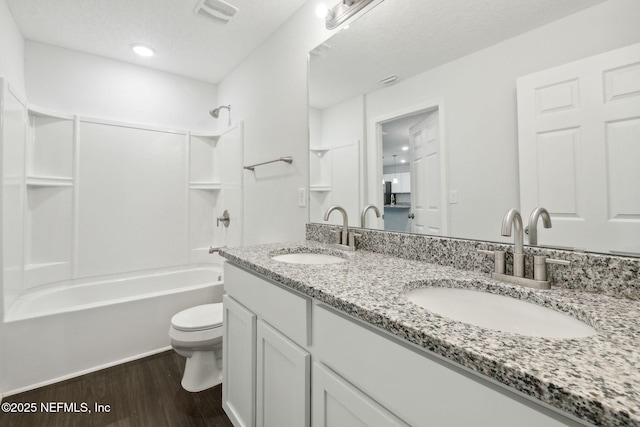 full bathroom featuring vanity, hardwood / wood-style floors,  shower combination, and toilet