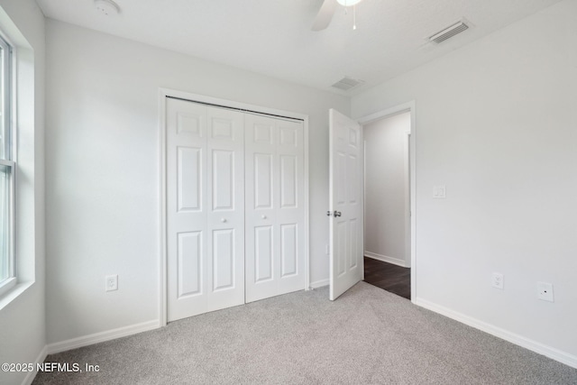 unfurnished bedroom featuring ceiling fan, carpet floors, and a closet