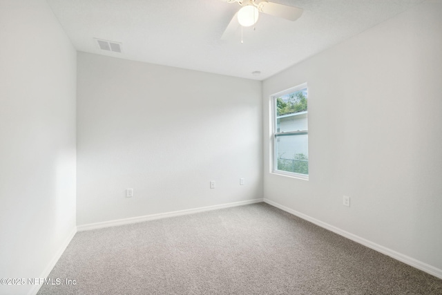 unfurnished room with ceiling fan and carpet