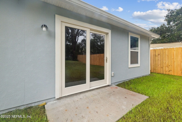 doorway to property featuring a yard and a patio area