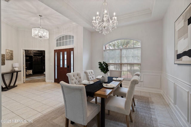 dining room featuring light tile patterned floors, a decorative wall, a notable chandelier, and a raised ceiling