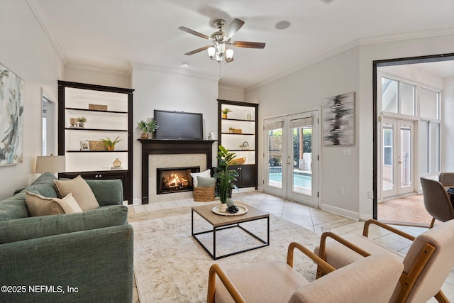 living area with french doors, a fireplace, light tile patterned flooring, and crown molding