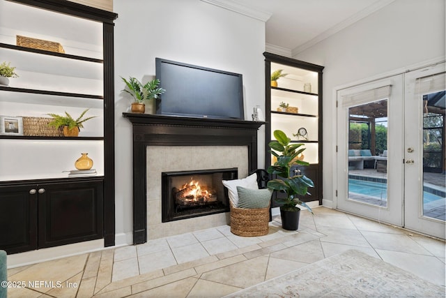 interior space with french doors, crown molding, and a lit fireplace