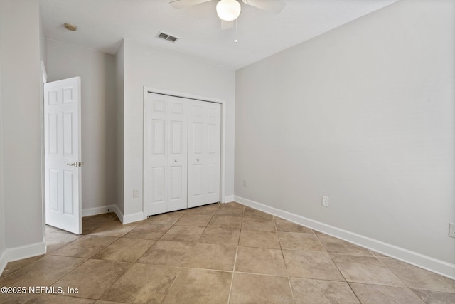 unfurnished bedroom featuring a closet, light tile patterned flooring, visible vents, and baseboards