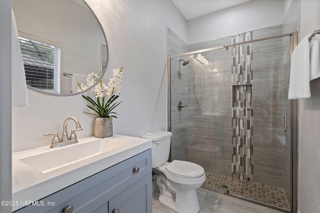 full bath with a stall shower, vanity, and toilet