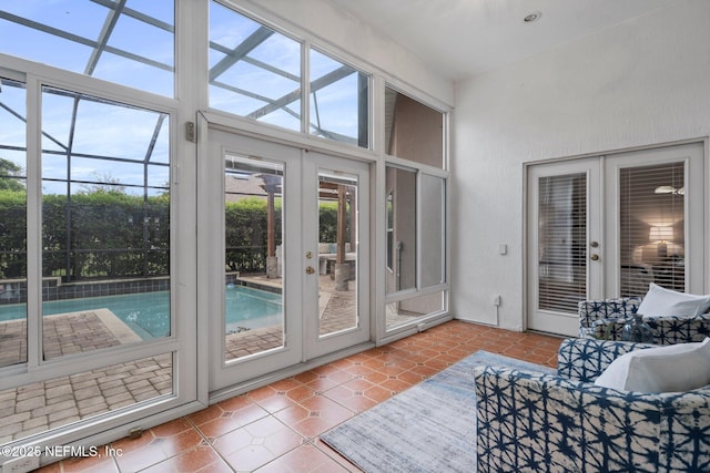 doorway to outside featuring tile patterned floors, a sunroom, and french doors