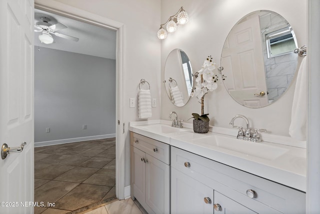 bathroom featuring double vanity, ceiling fan, baseboards, and a sink