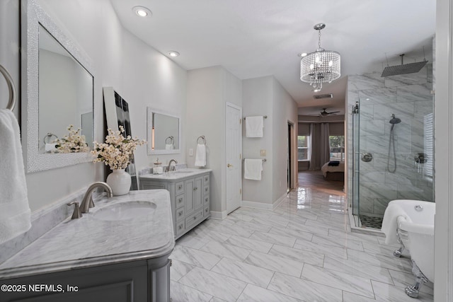 bathroom with a stall shower, baseboards, a sink, marble finish floor, and two vanities