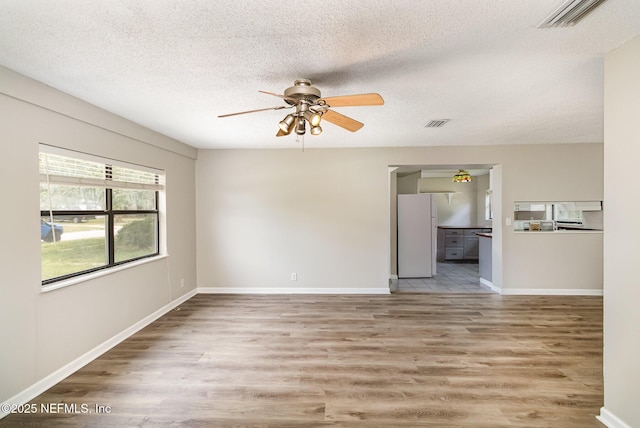 unfurnished room with ceiling fan, hardwood / wood-style floors, and a textured ceiling