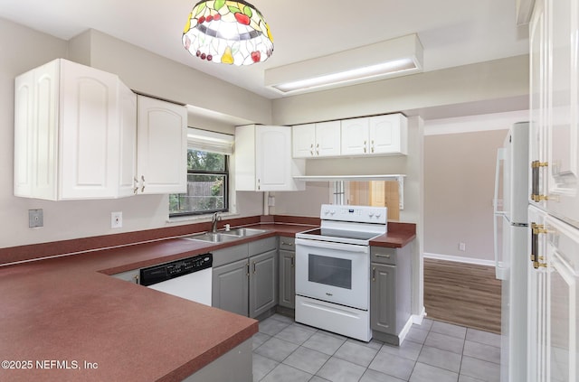 kitchen with light tile patterned flooring, sink, white cabinetry, gray cabinets, and white appliances