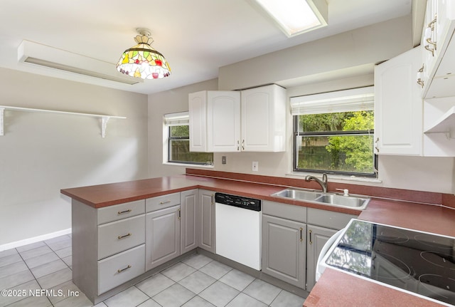 kitchen featuring sink, white cabinetry, stove, white dishwasher, and kitchen peninsula