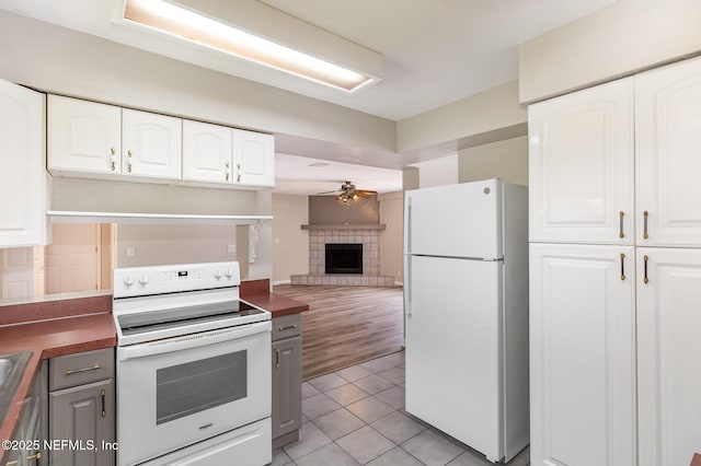 kitchen featuring ceiling fan, light tile patterned flooring, white cabinets, and white appliances