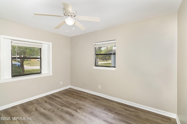 spare room with ceiling fan, a wealth of natural light, and wood-type flooring