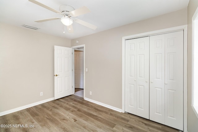 unfurnished bedroom featuring light hardwood / wood-style floors, a closet, and ceiling fan