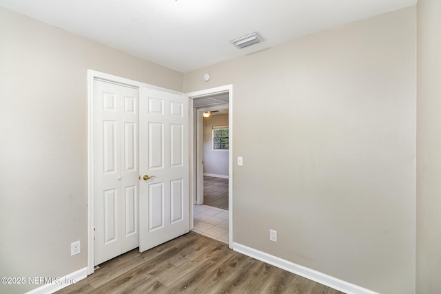 unfurnished bedroom featuring wood-type flooring and a closet