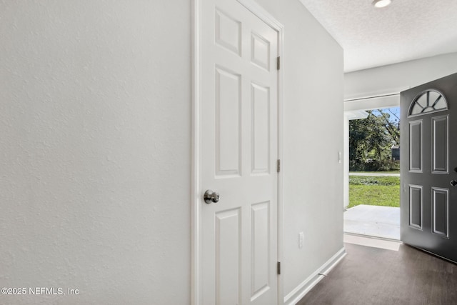 foyer entrance with a textured ceiling