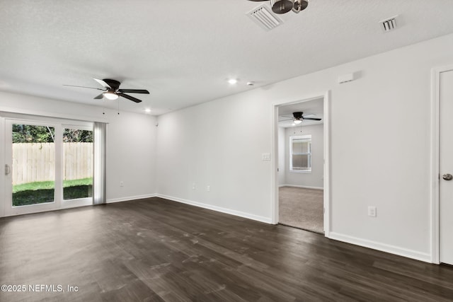 spare room with a textured ceiling, dark hardwood / wood-style floors, and ceiling fan