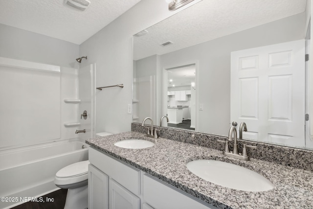 full bathroom featuring bathing tub / shower combination, vanity, a textured ceiling, and toilet