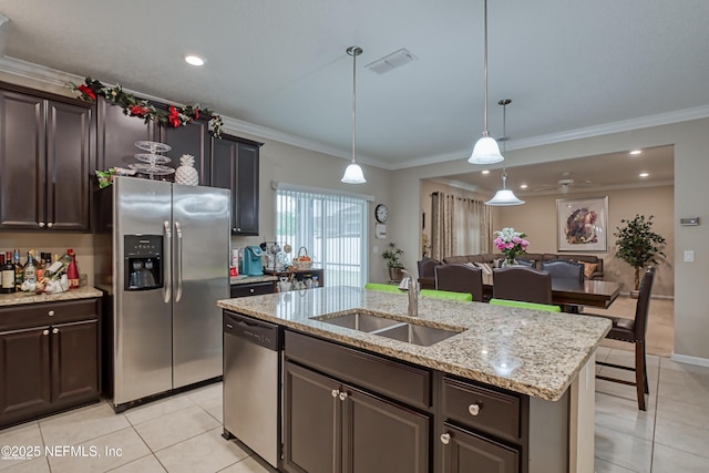 kitchen featuring sink, appliances with stainless steel finishes, a kitchen island with sink, dark brown cabinetry, and ornamental molding