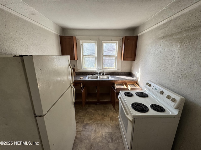 kitchen featuring sink, a textured ceiling, and white appliances