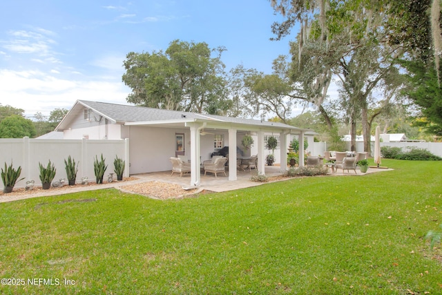 rear view of house featuring a yard and a patio