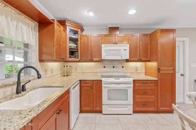 kitchen with sink, white appliances, light stone countertops, light tile patterned flooring, and decorative backsplash