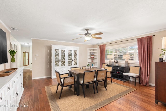 dining room with hardwood / wood-style flooring, crown molding, a textured ceiling, and ceiling fan