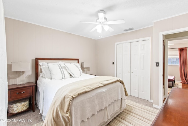 bedroom with ornamental molding, ceiling fan, and a closet